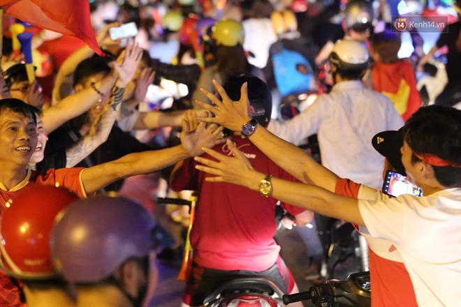 Những cái chạm tay của người xa lạ trên đường phố Sài Gòn hòa chung niềm vui chiến thắng cùng hàng triệu người Việt Nam - Ảnh: Tứ Quý
