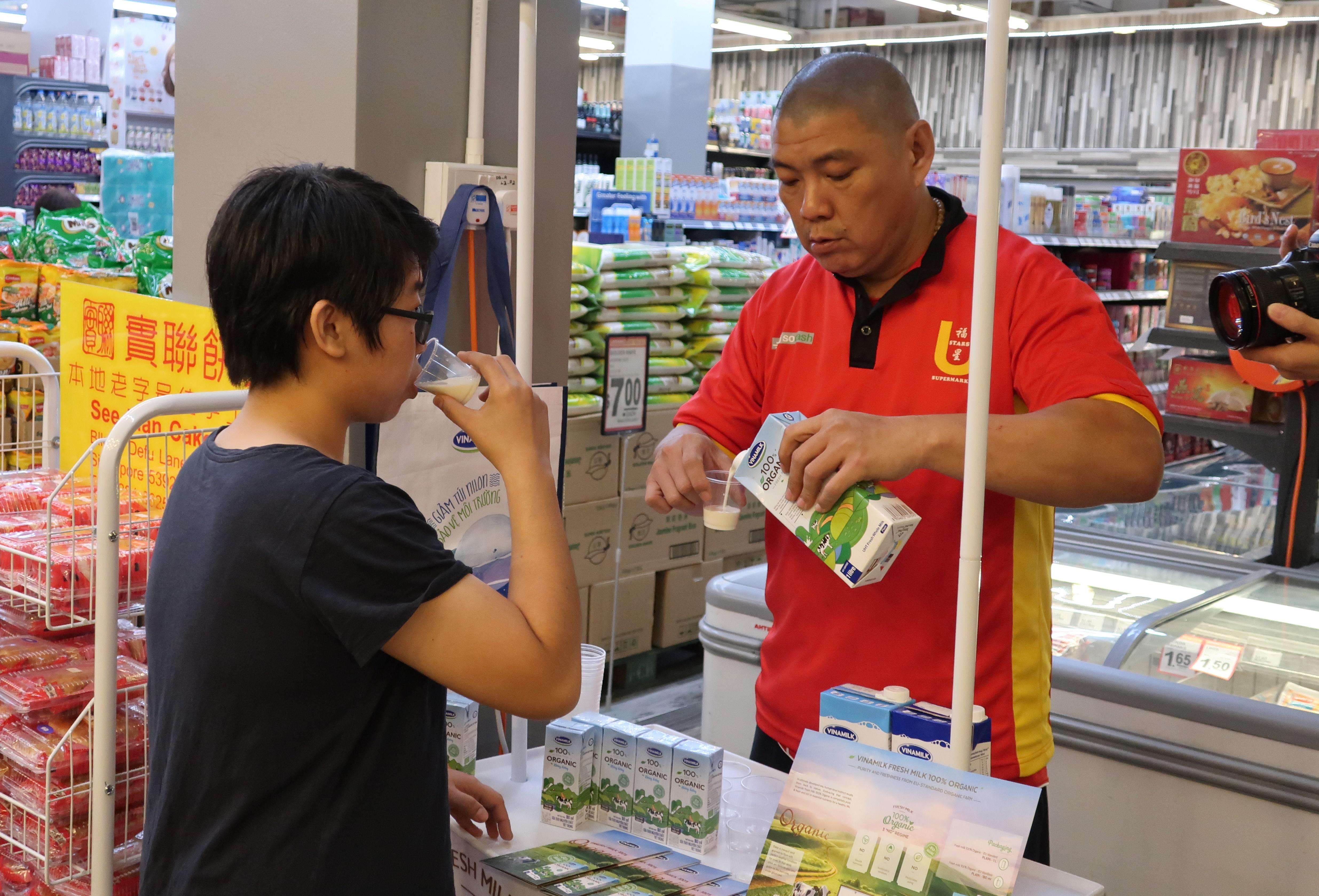  Người tiêu dùng Singapore tìm hiểu về sữa tươi Organic tại quầy dùng thử sản phẩm sữa Vinamilk trong các siêu thị