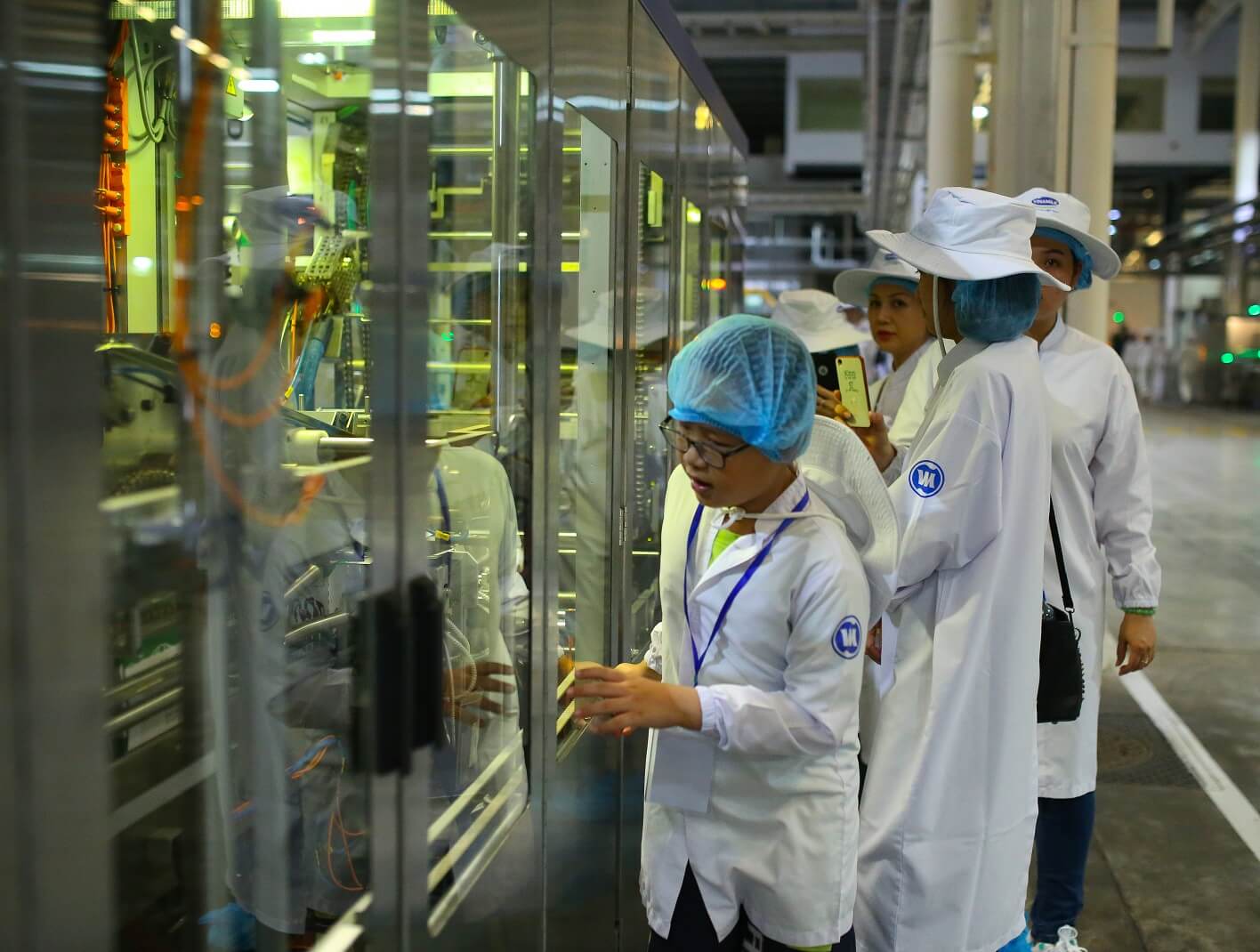 Bé Ngô Nguyễn Hoàng Huy (bìa phải) tiết lộ: "Con thích nhất là công nghệ ở nhà máy sữa, rất ít các cô chú công nhân nhưng mọi dây chuyền vẫn hoạt động nhanh gọn, hộp sữa học đường được làm ra cho chúng con thật là kỳ công.”