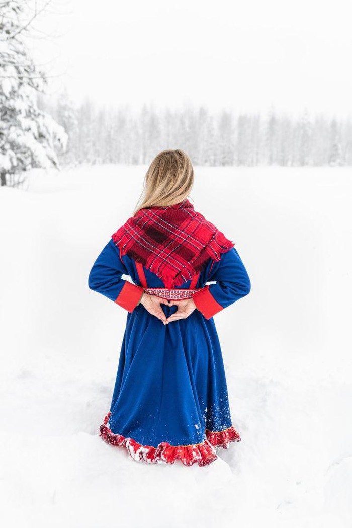 Cô gái quàng khăn đứng trên cánh đồng tuyết trắng.