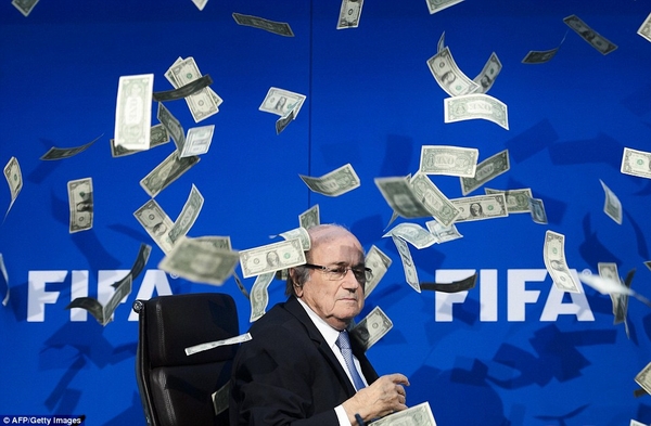 Chủ tịch FIFA Sepp Blatter ngượng chín mặt khi bị diễn viên hài nổi tiếng của Anh - Lee Nelson ném tiền vào người, sau khi hàng loạt scandal tham nhũng, hối lộ tại FIFA bị phát giác.