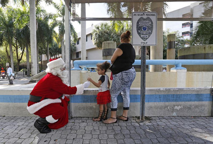 Ông già Noel tặng quà cho một bé gái bên ngoài Bệnh viện Holtz trẻ em tại Miami. 