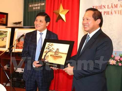 Bộ trưởng Trương Minh Tuấn trao tượng trưng kho ảnh quý Khám phá Việt Nam cho Đại sứ Trương Mạnh Sơn. (Ảnh: Ngọc Mai/Vietnam+)