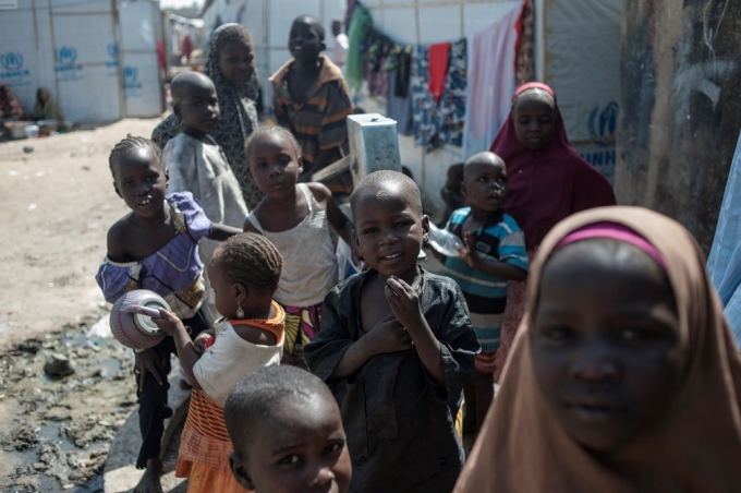   Trẻ tị nạn tại thành phố Maiduguri, Nigeria chơi đùa quanh một miệng giếng khoan. Theo các tổ chức phi chính phủ, có khoảng 2,6 triệu người phải di dời nơi ở, trong đó bao gồm 1,4 triệu trẻ em và 2,2 triệu người khác bị mắc kẹt ở các khu vực do băng nhóm khủng bố Boko Haram kiểm soát (Ảnh: Stefan Heunis / AFP / Getty Images)  