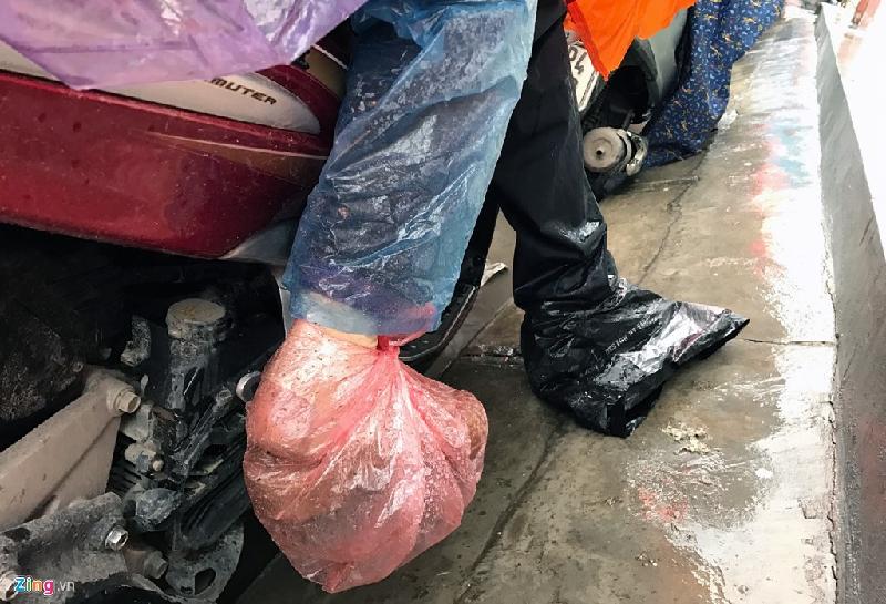 Nhiều người đối phó với tình trạng mưa rả rích gây bẩn thỉu bằng cách bọc nilon vào giầy khi ngồi trên xe máy.