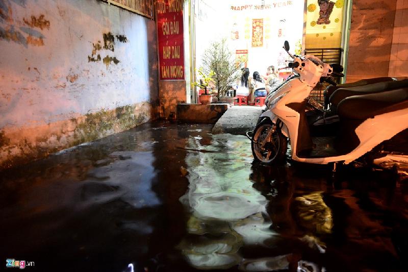 Nhân viên một quán cắt tóc trên đường Phan Anh ăn tối bên ngoài mênh mông nước. Ngoài ra, các tuyến đường khác trên địa bàn quận Bình Tân như An Dương Vương, Tân Hòa Đông, Tên Lửa cũng ngập khá sâu.