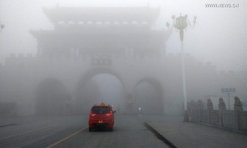 Một chiếc xe chạy trong sương mù ở tỉnh Hà Nam của Trung Quốc ngày 3/1/2017. Ảnh: Tân Hoa Xã.