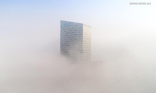 Một tòa nhà bị sương bao phủ ở An Huy ngày 3/1/2017. Ảnh: Xinhua