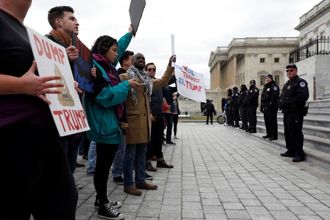Người biểu tình đối diện với lực lượng an ninh canh gác bên ngoài quốc hội Mỹ. Ảnh: Reuters.