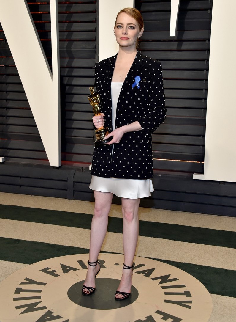 Emma Stone ăn mừng chiến thắng với phong cách đơn giản hơn bộ đầm ánh kim mặc trên thảm đỏ tối 26/2.  