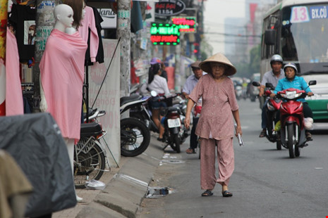 Cụ già đi dưới lòng đường bởi các hộ kinh doanh lấn chiếm vỉa hè trên đường Cách Mạng Tháng Tám (quận Tân Bình).