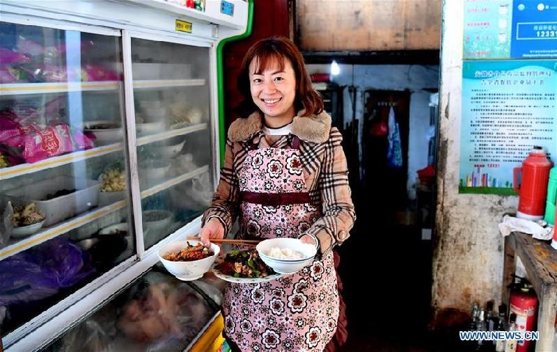 Cô Qing Ningling, chủ một quán trọ địa phương, chuẩn bị bữa trưa sau khi đón khách du lịch tới làng. 
