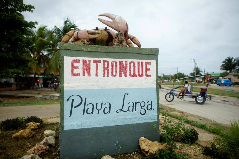 Một bức tượng con cua lớn đặt ở ngõ vào thị trấn Playa Larga, nằm bên bờ vịnh Con Lợn. Khu vực đã chứng kiến sự bùng nổ du lịch trong những năm gần đây, đặc biệt là sau khi quan hệ Mỹ - Cuba bớt căng thẳng.