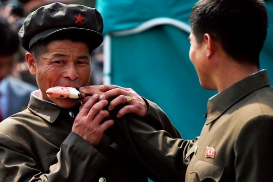 Đồng chí: Khoảnh khắc hai người đàn ông ở Bình Nhưỡng, Triều Tiên cùng ăn kem. Triều Tiên đón hàng trăm phóng viên quốc tế trong những ngày qua nhân dịp kỷ niệm 105 năm ngày sinh của ông Kim Nhật Thành. Ngay sau lễ duyệt binh hôm 15/4, nước này phóng tên lửa thất bại, khiến cộng đồng quốc tế lo lắng về tình hình an ninh ở Đông Á. Ảnh: Reuters.