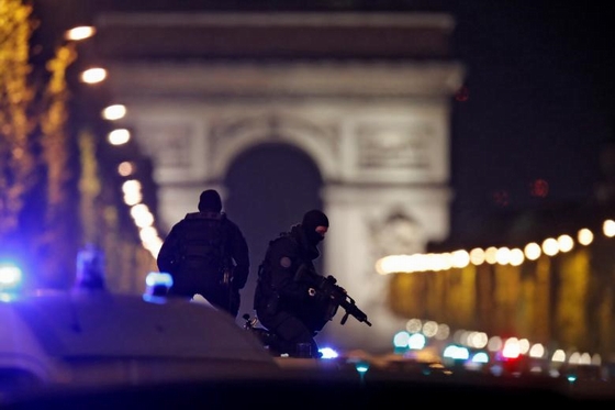 Kinh đô ánh sáng: Cảnh sát Pháp đeo mặt nạ đứng trên xe ôtô chuyên dụng ở đại lộ Champs Elyesees, trung tâm thủ đô Paris. Trước đó, một cảnh sát bị bắn chết và hai người khác bị thương trong một vụ xả súng. Ảnh: Reuters.