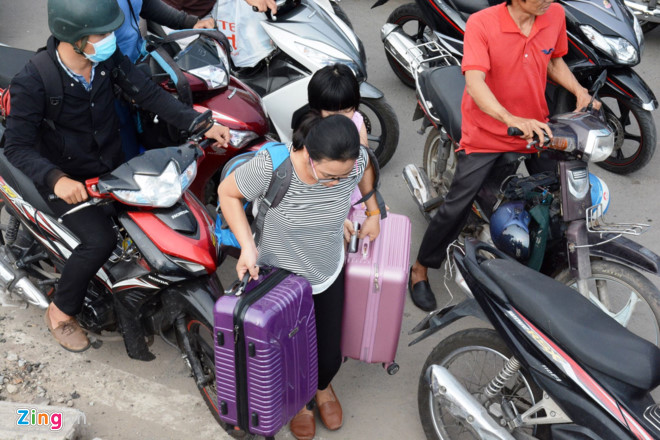 Hành khách lo lắng bị trễ chuyến bay trước tình trạng kẹt xe càng lúc càng nghiêm trọng, nhiều người đã vác hành lý chạy bộ vào sân bay Tân Sơn Nhất.