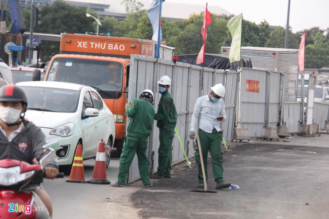 Trước tình trạng kẹt xe càng lúc càng nghiêm trọng, công nhân đang thi công công trình cầu vượt đã dời lô cốt trước sân bay Tân Sơn Nhất vào trong hơn 2 m, để xe cộ qua lại dễ dàng hơn.
