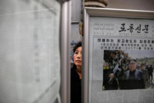 Một phụ nữ chăm chú đọc tin tức trên các báo mới ra.