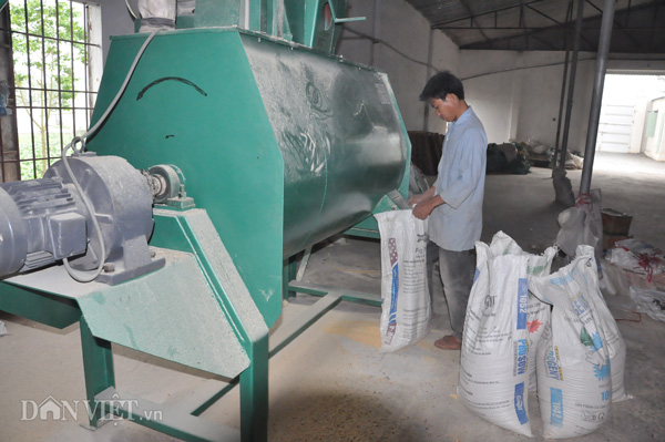 Công nhân sản xuất cám phục vụ đàn lợn tại trang trại của ông Long ở huyện Thanh Oai (Hà Nội).