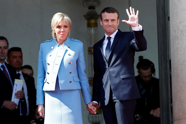 Ông Emmanuel Macron nắm tay phu nhân Brigitte Trogneux khi vẫy chào người tiền nhiệm Francois Hollande sau cuộc chuyển giao quyền lực. (Ảnh: Reuters)