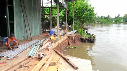 Một phần nhà máy xay xát của ông Trần Hoàng Nam bị nhấn chìm xuống sông.