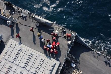 Các thủy thủ bị thương được buộc chặt vào băng ca để đưa lên trực thăng cấp cứu. Ảnh: Reuters
