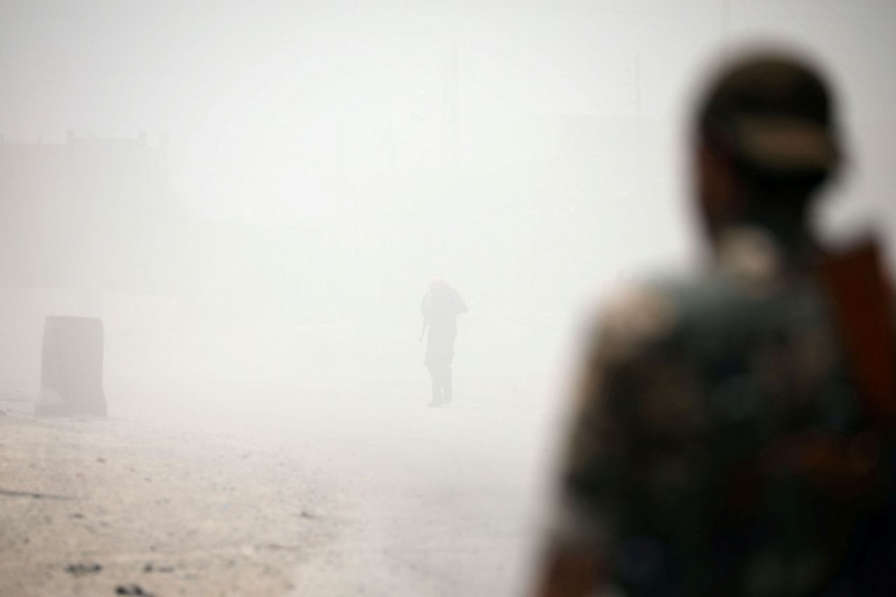 Chiến binh SDF trong khói lửa mịt mù của đạn bom (Ảnh: Reuters)