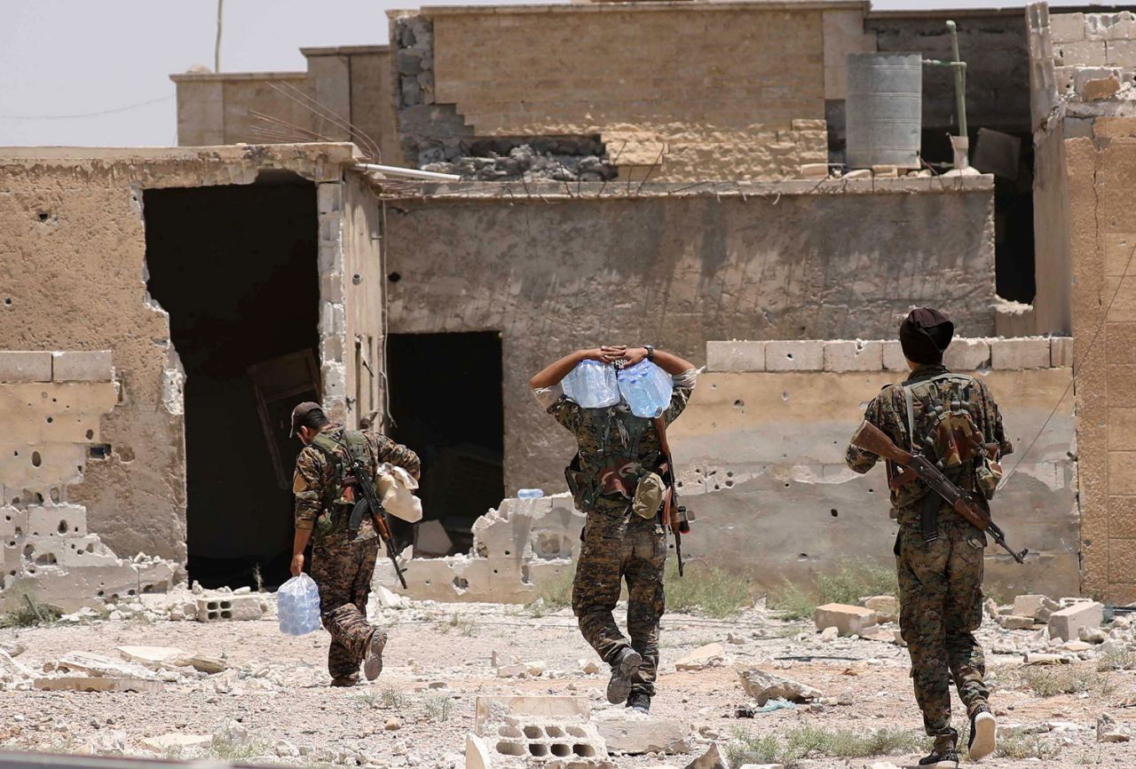 Chiến binh SDF đi lấy nước ở quận al-Sabahia, phía tây Raqqa (Ảnh: Reuters)