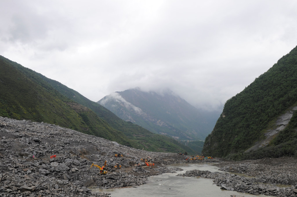 Mưa lớn trong sáng 24/6 khiến đất đá từ ngọn núi ập xuống làng Tân Ma. Ảnh: Reuters.