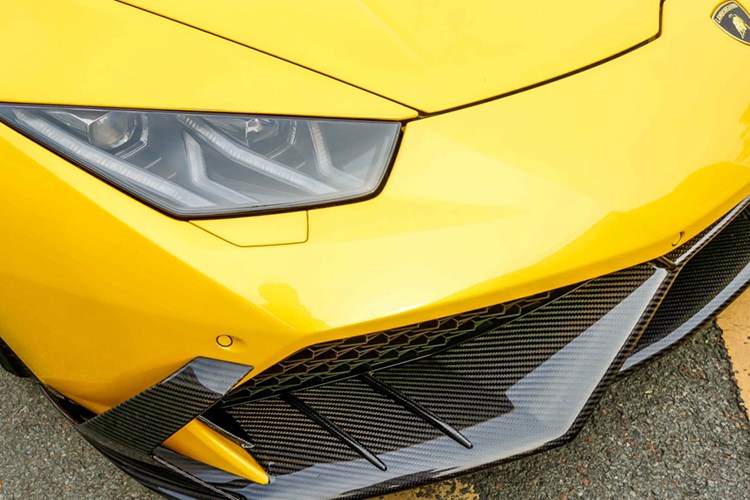 So với phiên bản tiêu chuẩn, siêu xe Lamborghini Huracan màu vàng được trang bị bộ body kit của hãng độ Mansory. Trong đó điểm nhấn là các chi tiết như cánh lướt gió phía trước và bên hông, vỏ gương, nắp khoang động cơ hay cản va sau được sử dụng chất liệu sợi carbon làm thiết kế.