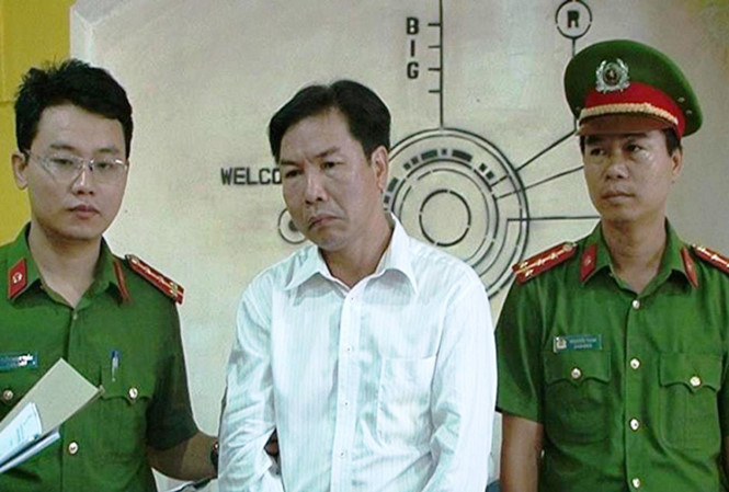 Thi hành lệnh bắt tạm giam đối với Lê Hữu Lam (áo trắng), nguyên giám đốc một trung tâm thuộc Ban quản lý Khu Kinh tế Chân Mây-Lăng Cô (tỉnh TT-Huế).