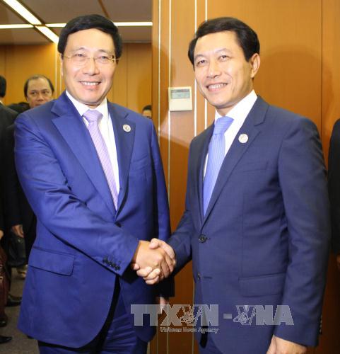 Phó Thủ tướng Phạm Bình Minh và Bộ trưởng Ngoại giao Lào Saleumxay Kommasith. Ảnh: TTXVN