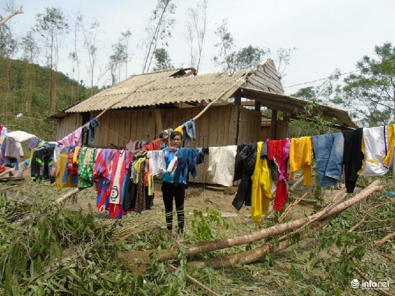 Chị Nguyễn Thị Hướng (thôn Tân Tiến) đang tranh thủ phơi quần áo bên cạnh ngôi nhà “mất nóc” của gia đình.
