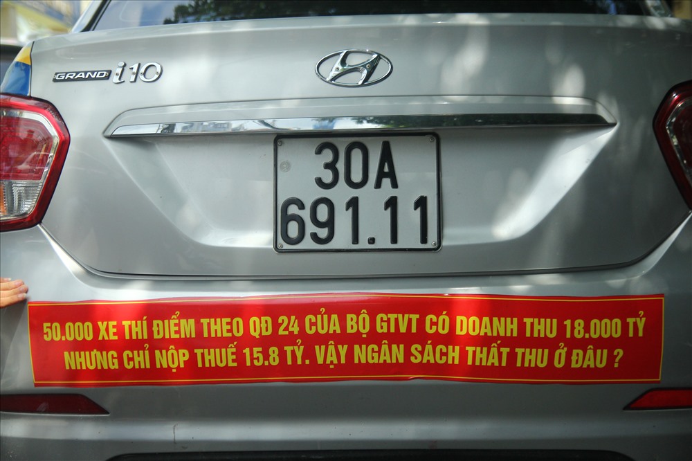 Taxi truyền thống dán khẩu hiệu phản đối quyết định của Bộ GTVT. Ảnh: Lao động