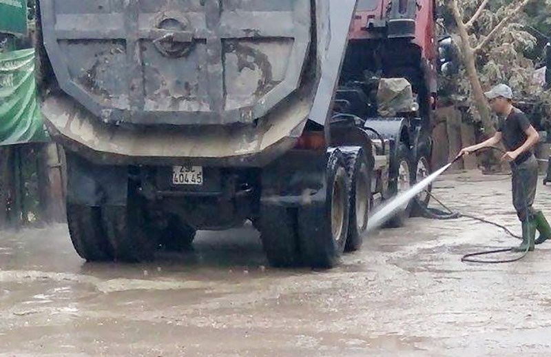 Xe tải chở vật liệu xây dựng trên đường phố phải xịt rửa sạch sẽ, che chắn thùng không làm vật liệu rơi vãi ra đường.