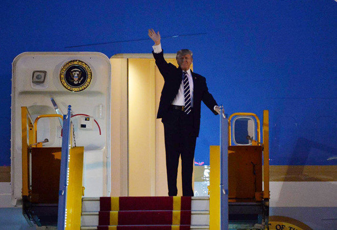 Tổng thống Trump đứng trên cửa chuyên cơ Air Force One ở sân bay Nội Bài vẫy chào mọi người. Ảnh: Zing
