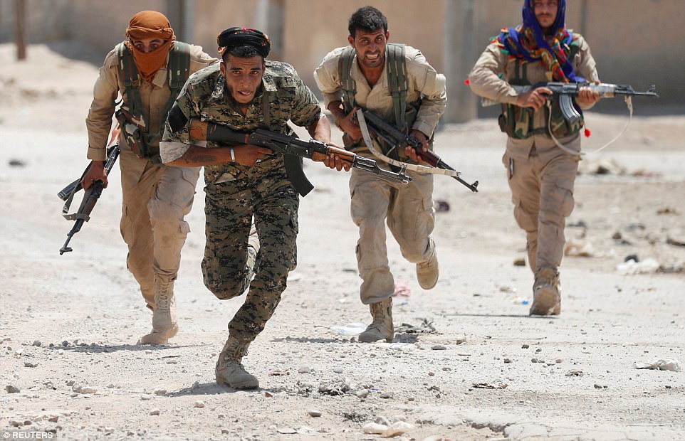 Bức ảnh của phóng viên ảnh Goran Tomasevic: Trong ảnh là lực lượng người Kurd thuộc Đơn vị Bảo vệ Nhân dân (YPG) đang chạy trên một con phố ở Raqqa, Syria, hôm 3/7