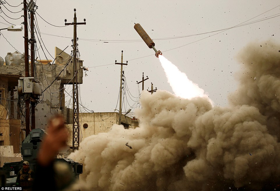 Bức ảnh của phóng viên ảnh Thaier Al-Sudani: Lực lượng phản ứng nhanh của Iraq bắn tên lửa tấn công IS trong trận chiến ở Mosul, Iraq, hôm 11/3.