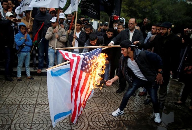Người dân Palestine đốt cờ của Israel và Mỹ trong một cuộc biểu tình phản đối ý định của Mỹ chuyển Đại sứ quán của họ tới Jerusalem và để công nhận thành phố Jerusalem là thủ đô của Israel, tại thành phố Gaza ngày 6/12/2017. Ảnh: Reuters
