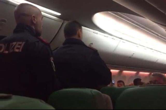 Cảnh sát lên máy bay áp giải những hành khách xô xát xuống máy bay. Ảnh: Mirror