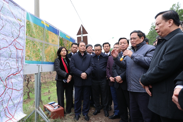 Thủ tướng Phạm Minh Chính đi kiểm tra thực địa dự án đường Vành đai 4 Vùng Thủ đô tại khu vực nút giao với đại lộ Thăng Long - Ảnh: VGP