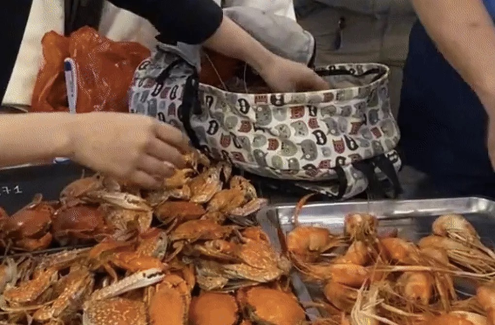 Nhóm khách ăn buffet rồi nhét 10kg hải sản vào túi mang về (Ảnh cắt từ video).