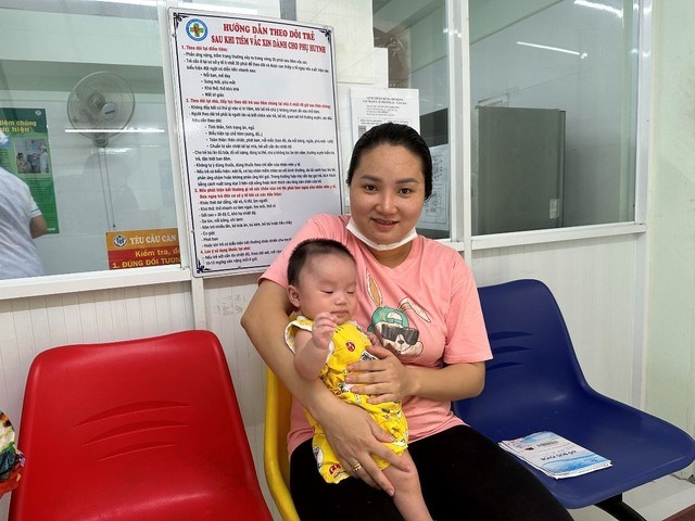 Phụ huynh vui mừng đưa con đi tiêm vaccine 5 trong 1 tại quận Bình Thạnh. Ảnh: HCDC.