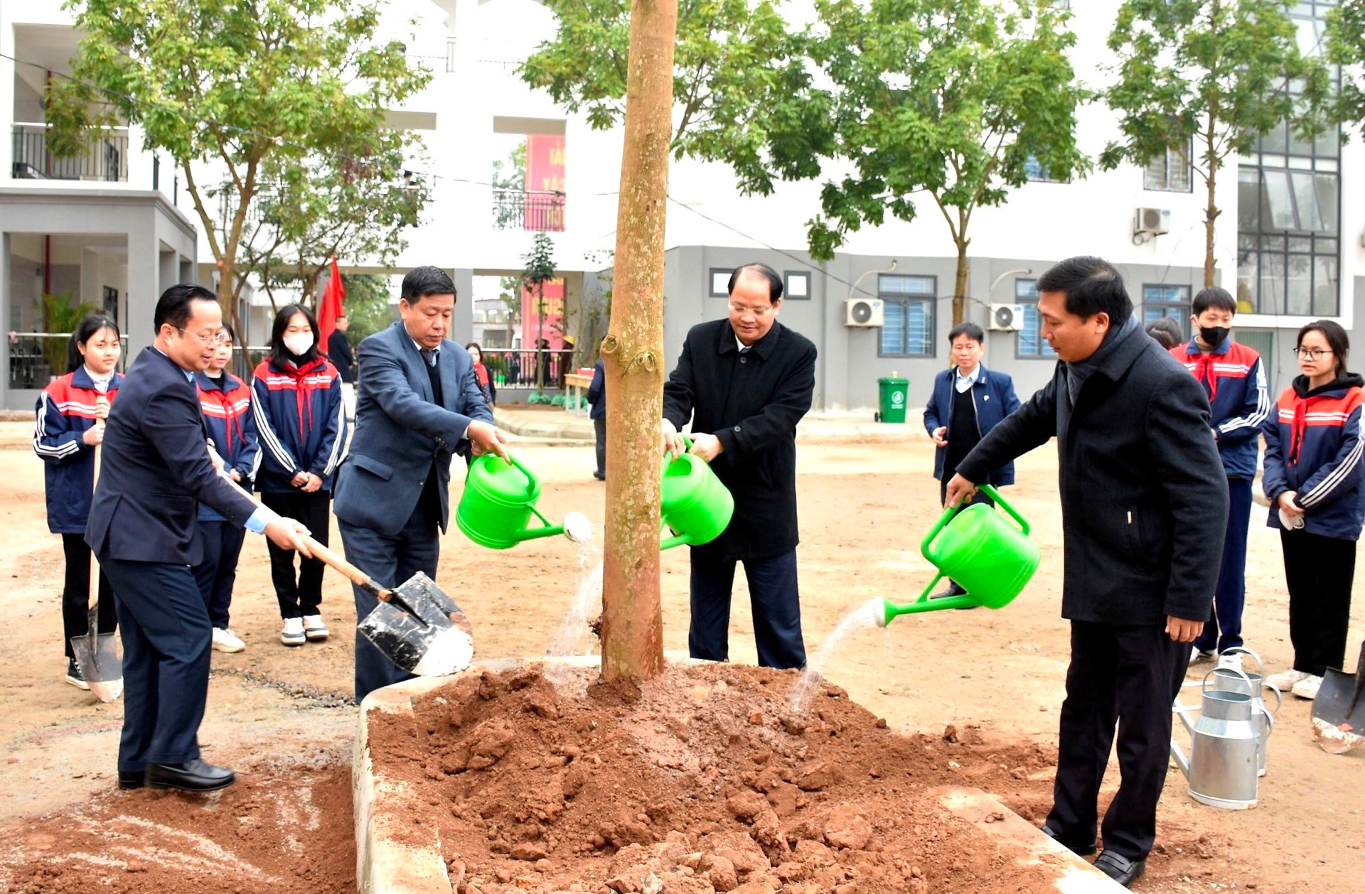 Các đồng chí lãnh đạo thành phố và ngành Giáo dục Hà Nội trồng cây xanh tại Trường THCS Trưng Vương (huyện Mê Linh).