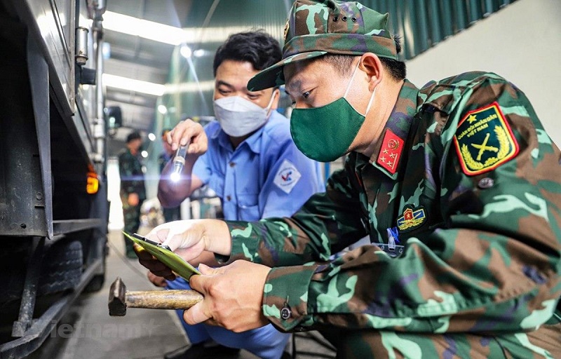 Đăng kiểm viên quân đội phối hợp với nhân viên đăng kiểm thực hiện quy trình kiểm định xe cơ giới. (Ảnh: Hoài Nam/Vietnam+)