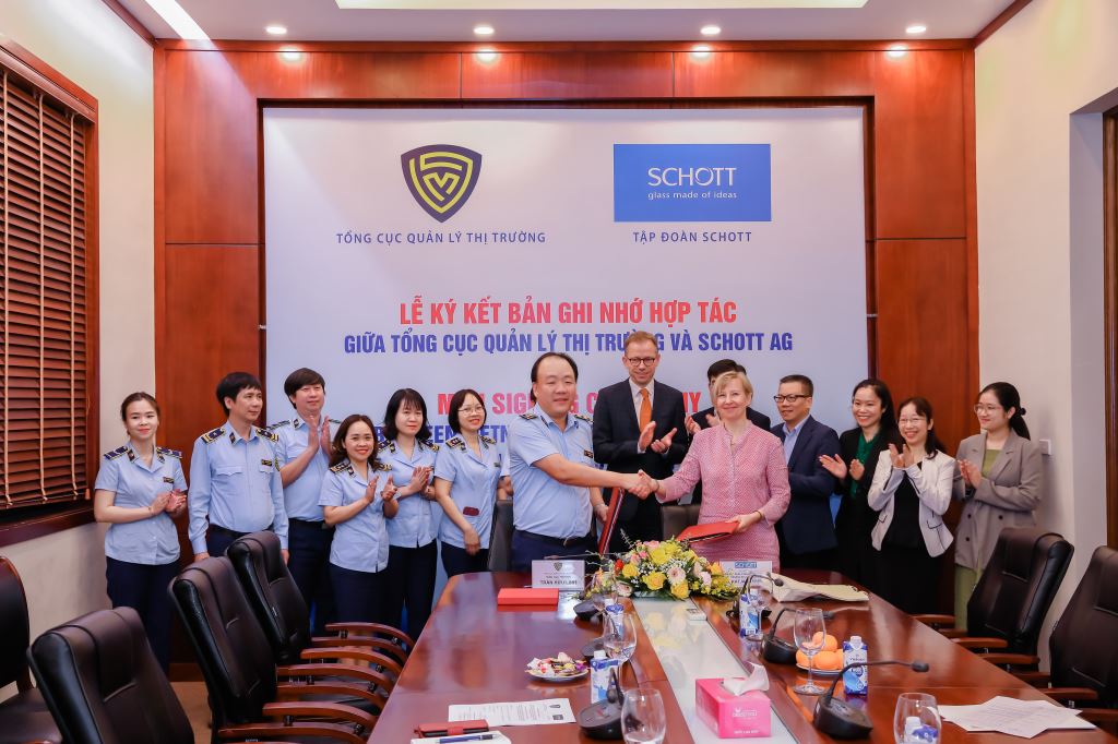Ông Trần Hữu Linh, Tổng cục trưởng Tổng cục QLTT bắt tay với bà Katja Dybowski, Giám đốc kinh doanh CERAN(R) châu Á, tập đoàn SCHOTT AG tại lễ ký kết