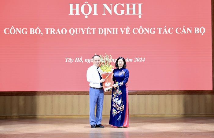 Phó Bí thư Thường trực Thành ủy Nguyễn Thị Tuyến trao quyết định, tặng hoa chúc mừng ông Nguyễn Lê Hoàng