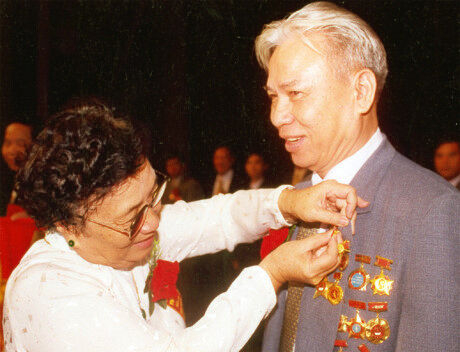 Nguyên Phó Chủ tịch Nước Nguyễn Thị Bình gắn huy hiệu Anh hùng Lao động cho đồng chí Đặng Văn Thân năm 2000.