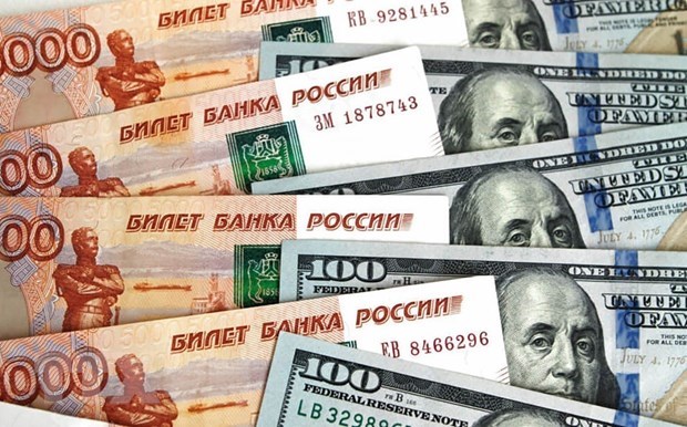 Đồng ruble (bên trái) và đồng USD (bên phải). (Ảnh: Sputnik/TTXVN)
