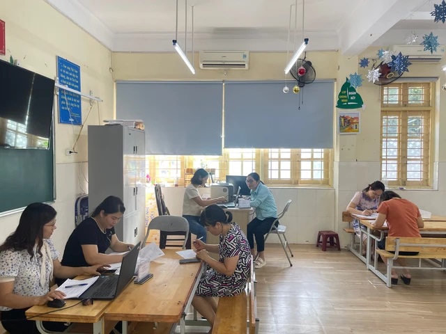 Hỗ trợ phụ huynh học sinh đăng ký tuyển sinh trực tuyến tại Trường Tiểu học Văn Yên, quận Hà Đông (Ảnh: Hà Nội mới)